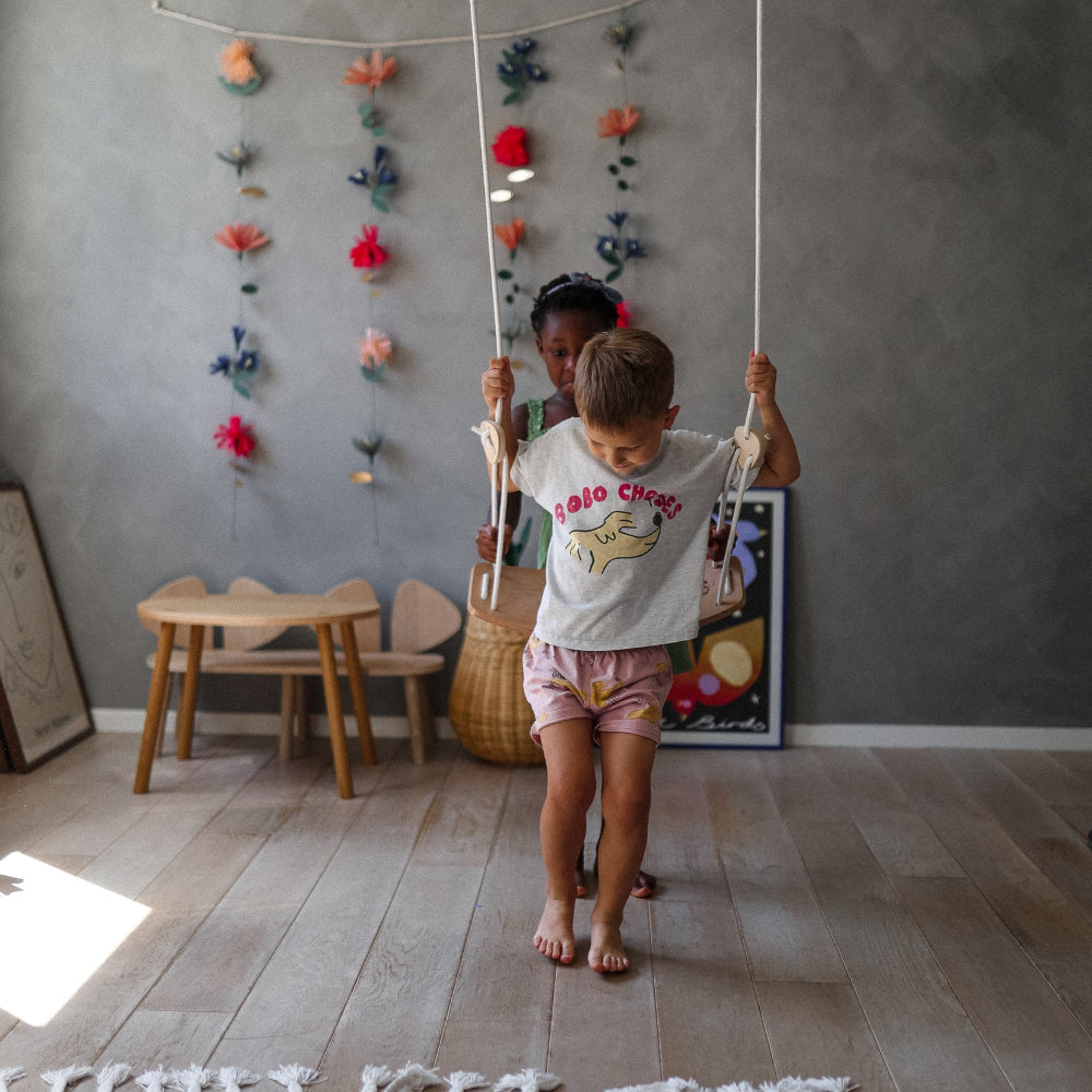 Kinderfeets child's swing with a wooden seat and ropes, designed for safe indoor or outdoor play for kids.