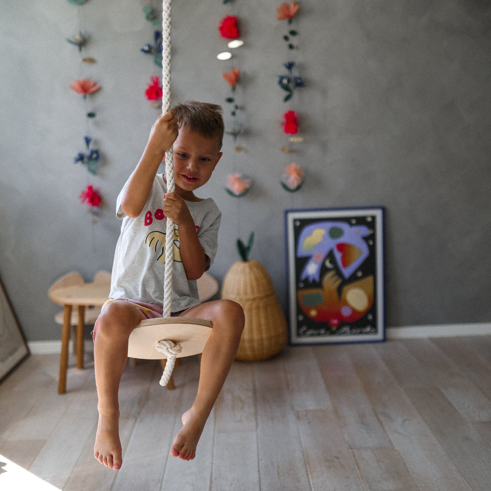 Kinderfeets Swinging Disc toy with colorful design, featuring a wooden handle and vibrant fabric for indoor play.