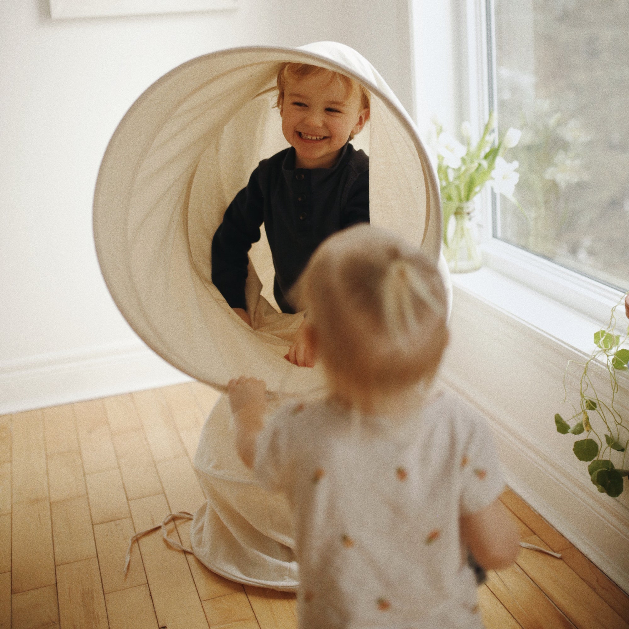 Kinderfeets Pikler Play Tunnel for children, soft fabric with colorful stripes, designed for safe indoor play and exploration.