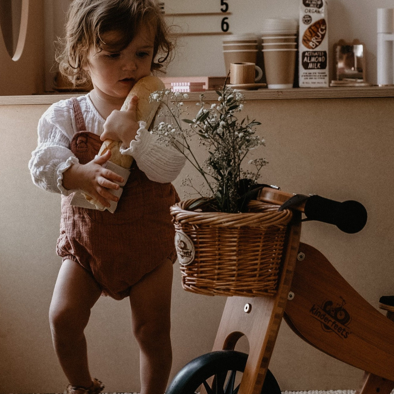 Kinderfeets wicker basket attached to colorful balance bike, designed for young children to carry small items.