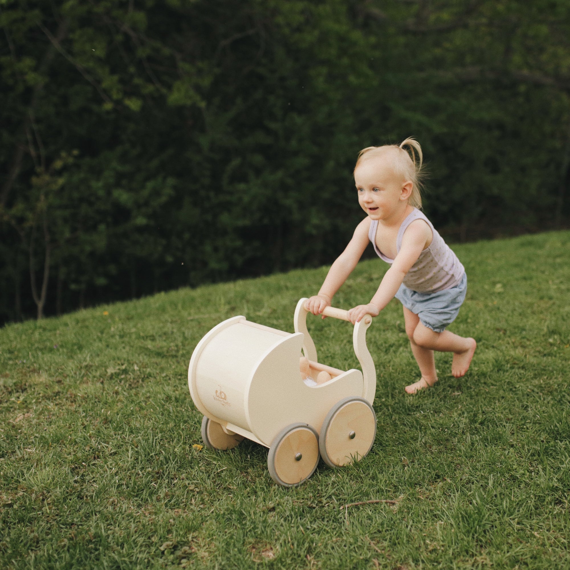 Wooden Kinderfeets Petit Pram toy with a classic design, featuring smooth wooden finish and colorful accents for young children.