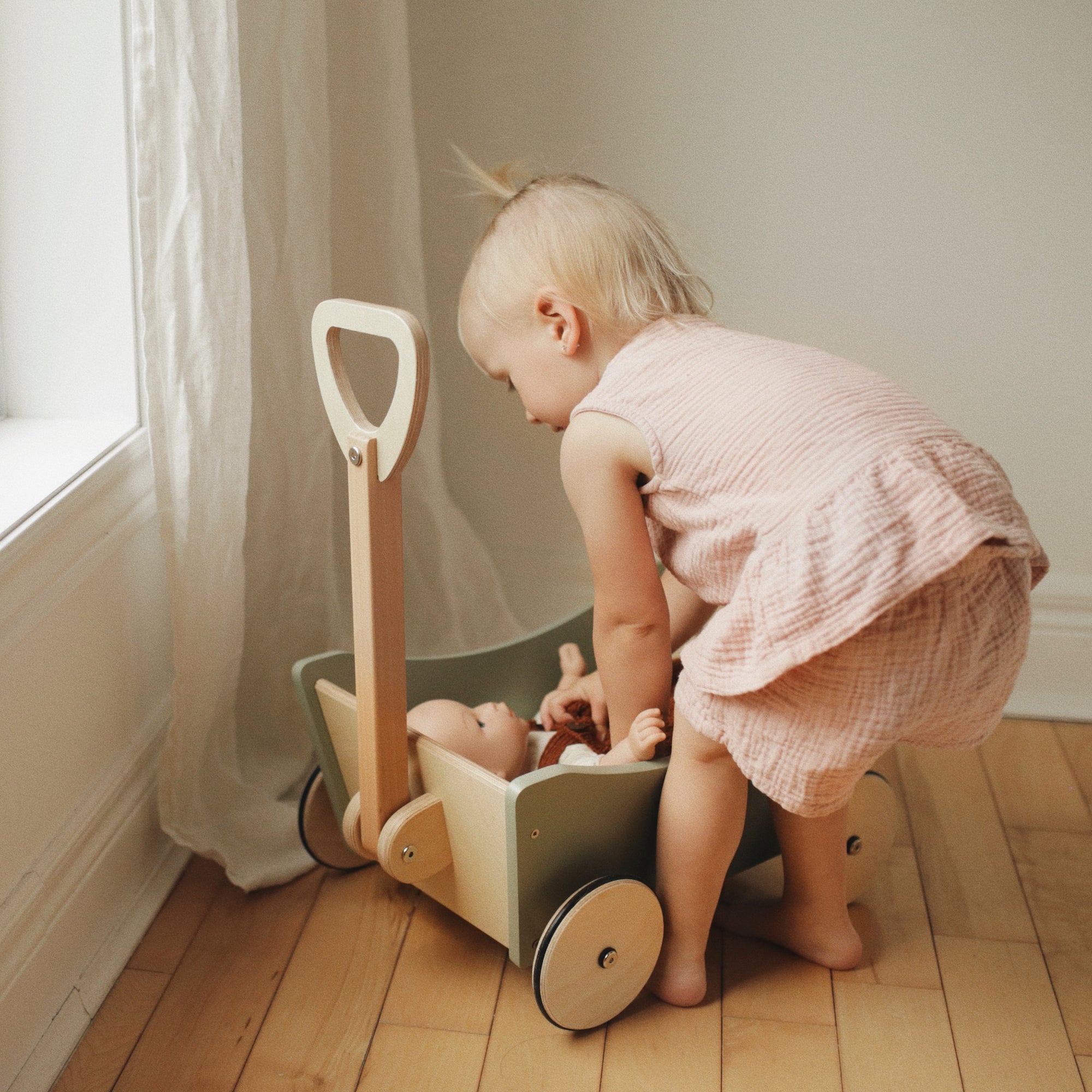 Wooden Kinderfeets Pull Wagon toy with colorful handles and wheels, designed for young children to pull and play.