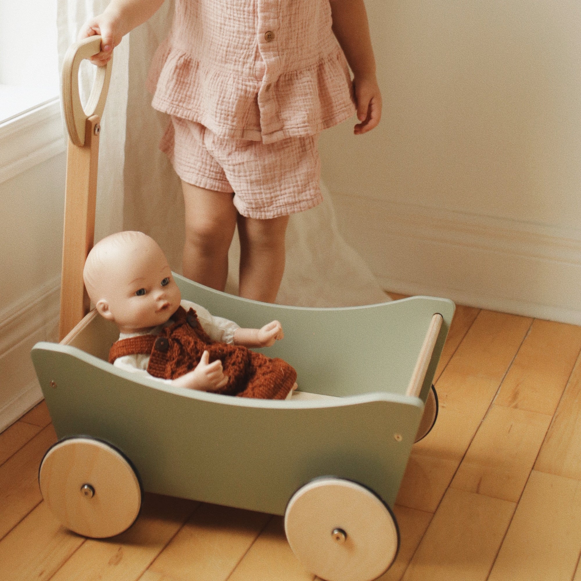 Wooden Kinderfeets Pull Wagon toy with colorful handle and wheels, designed for children to pull and play.