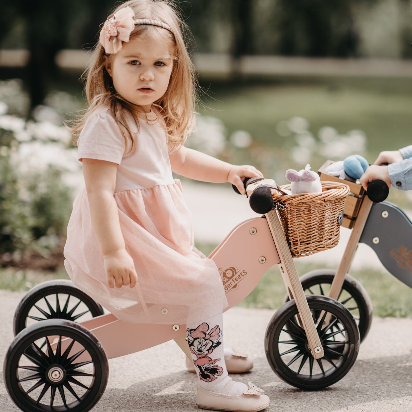 Kinderfeets Tiny Tot Plus pink trike and balance bike for toddlers, with a sturdy wooden frame and colorful wheels.