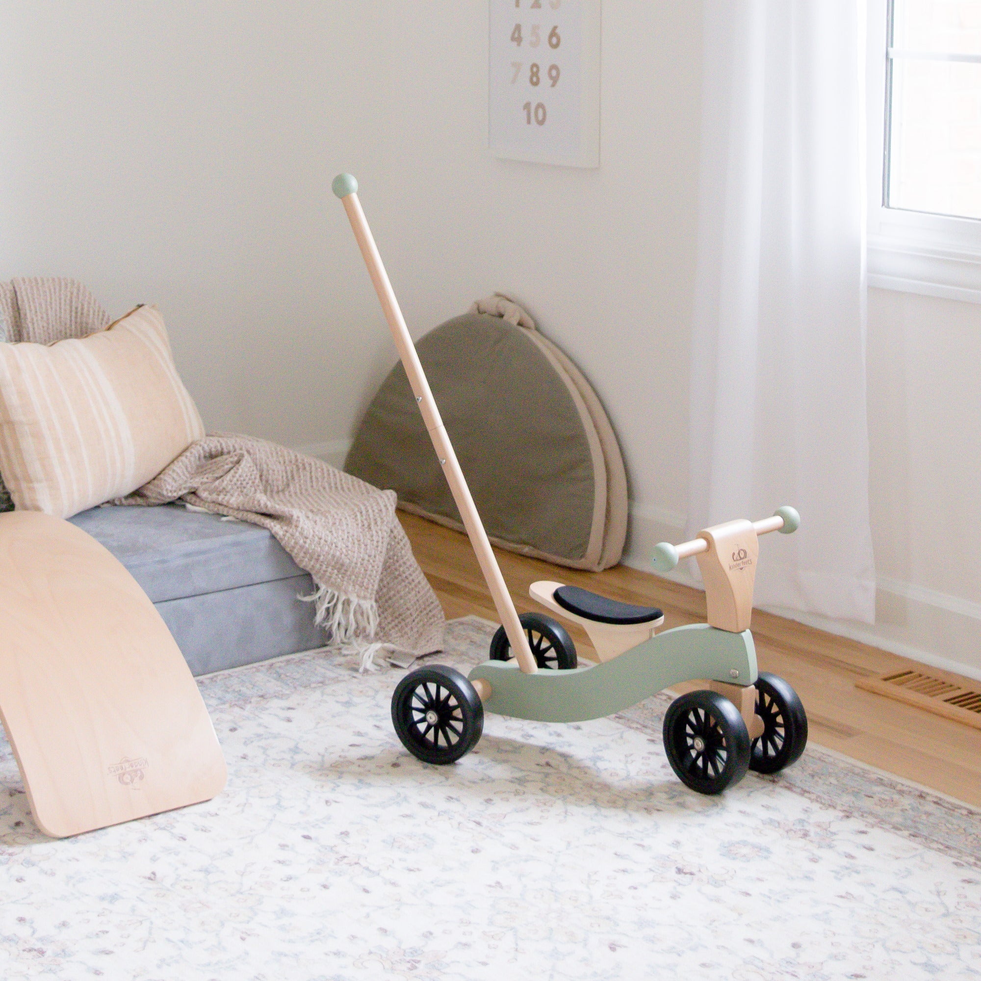 KINDERFEETS Tiny Glider toy in vibrant colors, featuring a small wooden balance bike for young children.