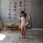 Kinderfeets child's swing with a wooden seat and ropes, designed for safe indoor or outdoor play for kids.