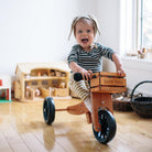 Kinderfeets Tiny Tot Mocha balance bike with training wheels and wooden frame, designed for young children learning to ride.