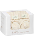 Cream Toshi organic baby booties with soft knitted fabric and adorable design for infants.