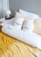 Belly Bliss pregnancy pillow in soft fabric, shaped to support pregnant belly and back during sleep.