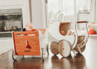 Kinderfeets wooden pram walker in white, designed for toddlers, featuring a classic toy with adjustable parts and colorful details