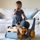 Kinderfeets Cargo Walker in slate blue, a wooden toy for toddlers with a sturdy handle and colorful cargo basket for imaginative play.