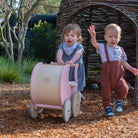 Wooden Kinderfeets Pram Walker in rose color, designed for young children, featuring a sturdy wooden frame and playful design.