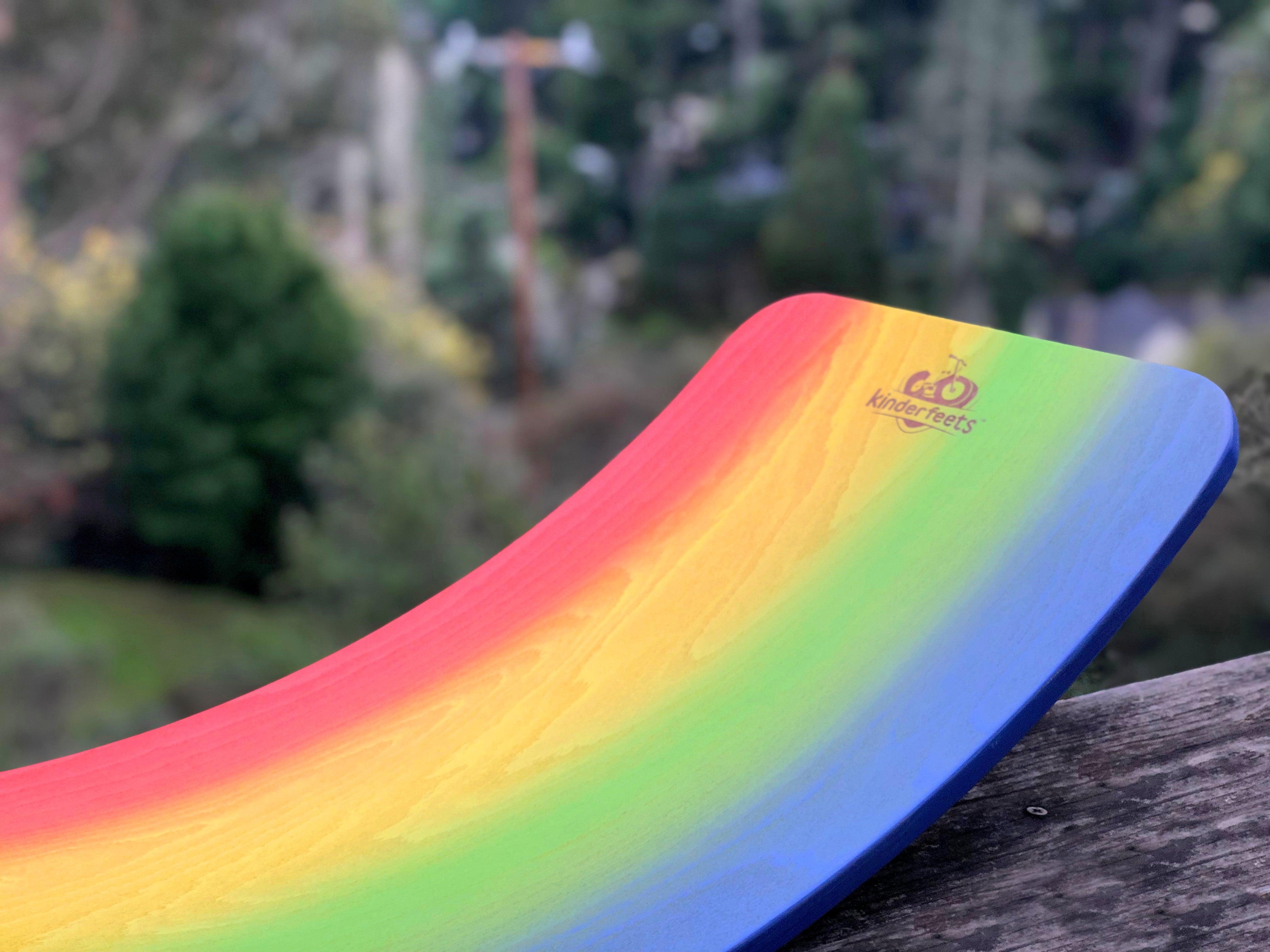 Kinderfeets Rainbow Kinderboard balance board with colorful rainbow design, featuring a smooth wooden surface and rounded edges.