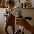 Kinderfeets wicker basket attached to colorful balance bike, designed for young children to carry small items.