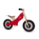Kinderfeets Cherry Red balance bike for kids, featuring a wooden frame and ergonomic handlebars, shown from the right side.