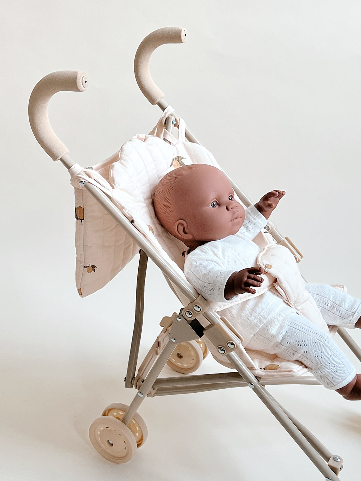 Konges Slojd Cherry Blush doll stroller accessory with a pink fabric seat and white frame, designed for children's dolls.