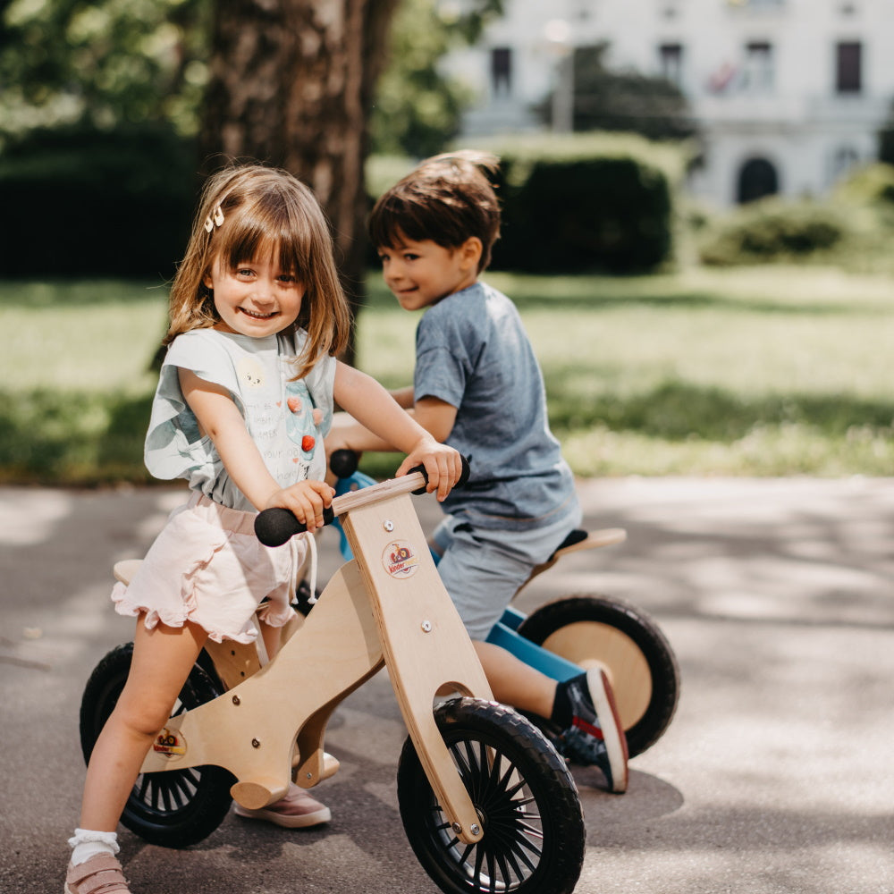Kinderfeets black balance bike for kids with a simple frame, wooden wheels, and ergonomic handlebars, ideal for beginner riders.