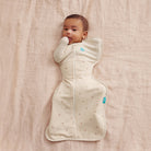 Love To Dream Swaddle Up All Seasons 1.5 TOG in Twigs, a soft baby swaddle with a leafy pattern, designed for comfortable sleep.
