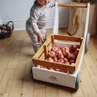 Kinderfeets Cargo Walker in white, a wooden toy designed for toddlers, featuring a classic, sturdy construction with a cargo storage area.