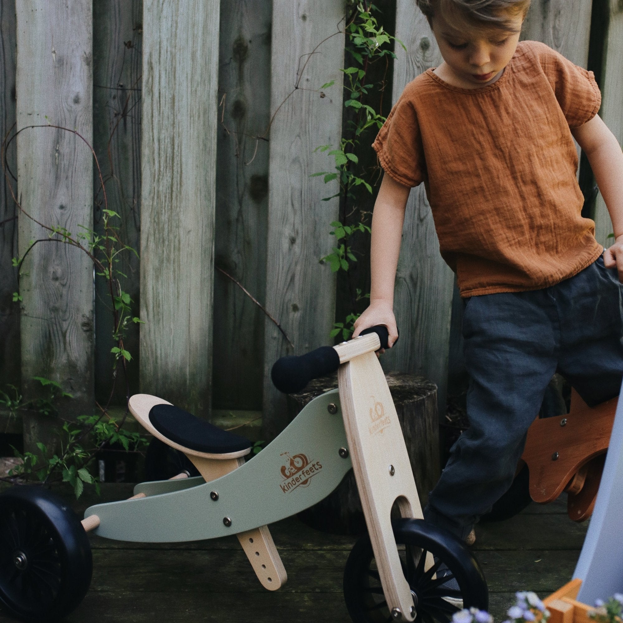 Kinderfeets Tiny Tots Plus slate grey balance bike for toddlers, featuring a sturdy frame and ergonomic design for young children.