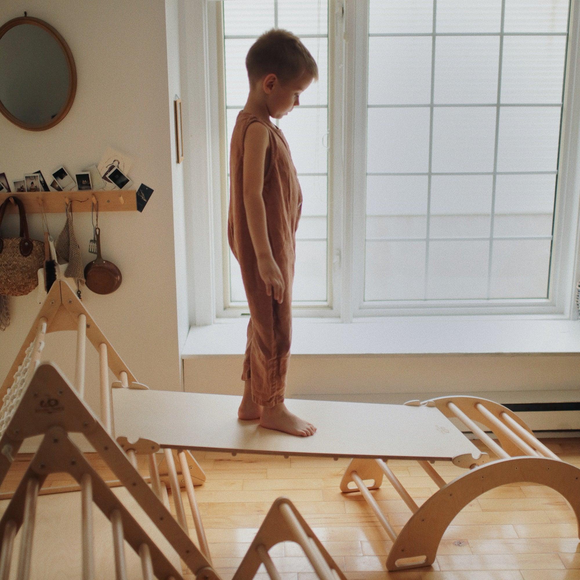 Kinderfeets Pikler ramp and slide climbing toy for toddlers, featuring wooden construction and colorful slide for active play.