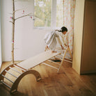 Kinderfeets Pikler climbing toy with a wooden arch and climbing steps, designed for safe, fun indoor play for children.
