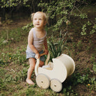 Wooden Kinderfeets Petit Pram toy with a natural wood finish, designed for children to simulate strolling and imaginative play.
