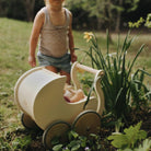 Kinderfeets Petit Pram wooden toy stroller with a natural wood finish, designed for young children to play and explore.