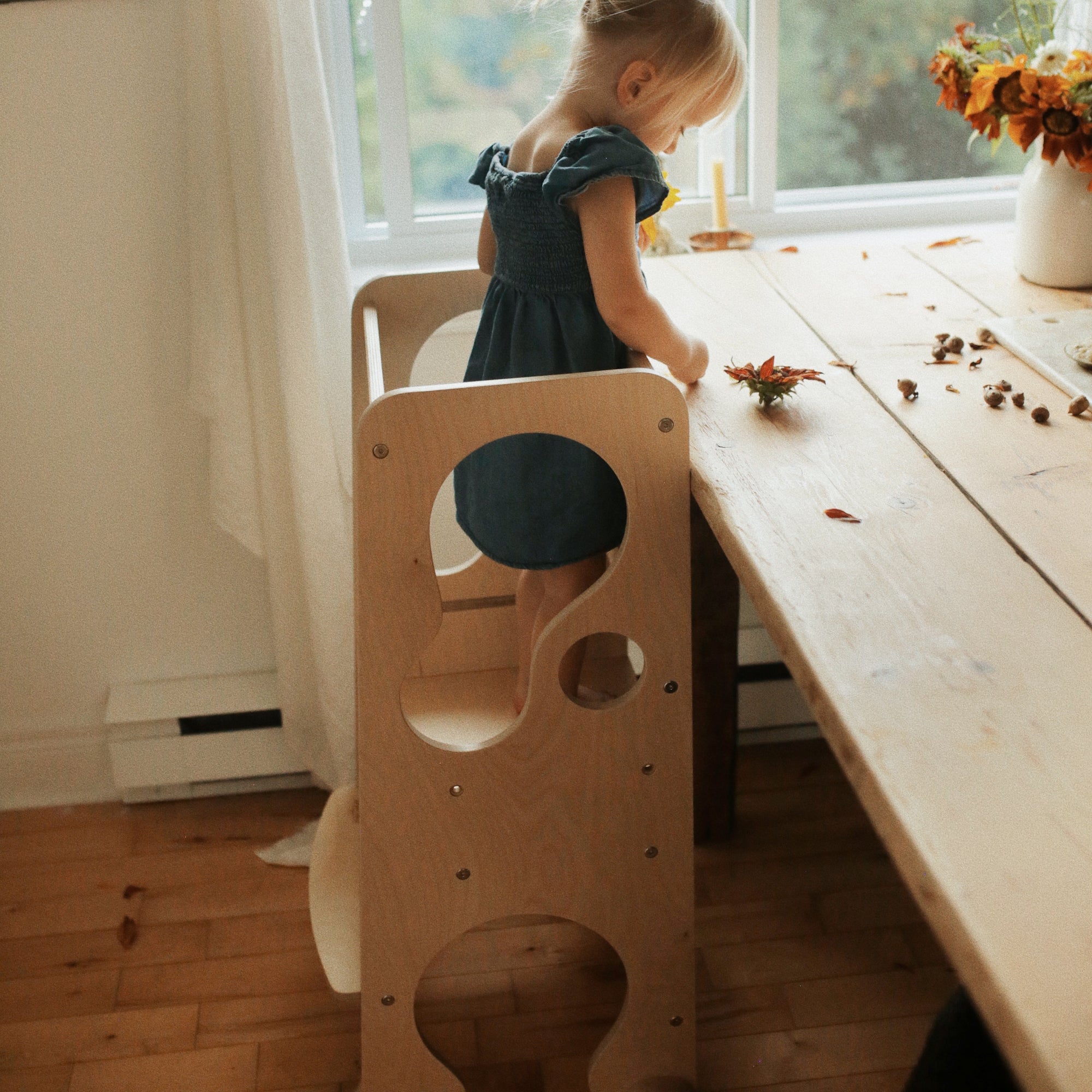 Kinderfeets Pikler Learning Tower in natural wood finish, featuring a sturdy wooden structure with safety rails for children.