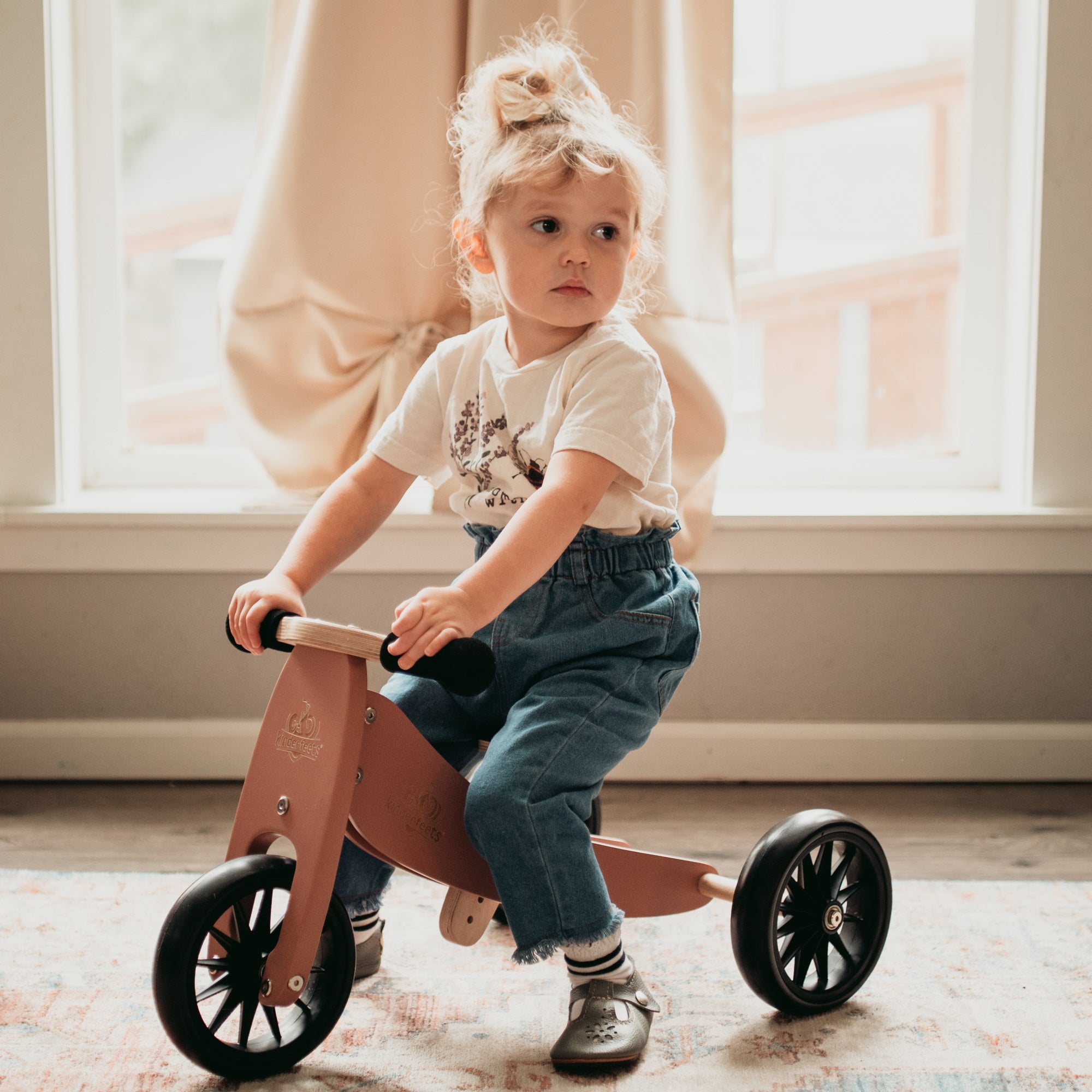Kinderfeets Tiny Tot coral balance bike for toddlers, featuring a lightweight frame and easy-to-grip handlebars, perfect for young children.