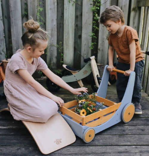 Kinderfeets Cargo Walker wooden toy in mocha color with four wheels and a handle for young children to push and explore.