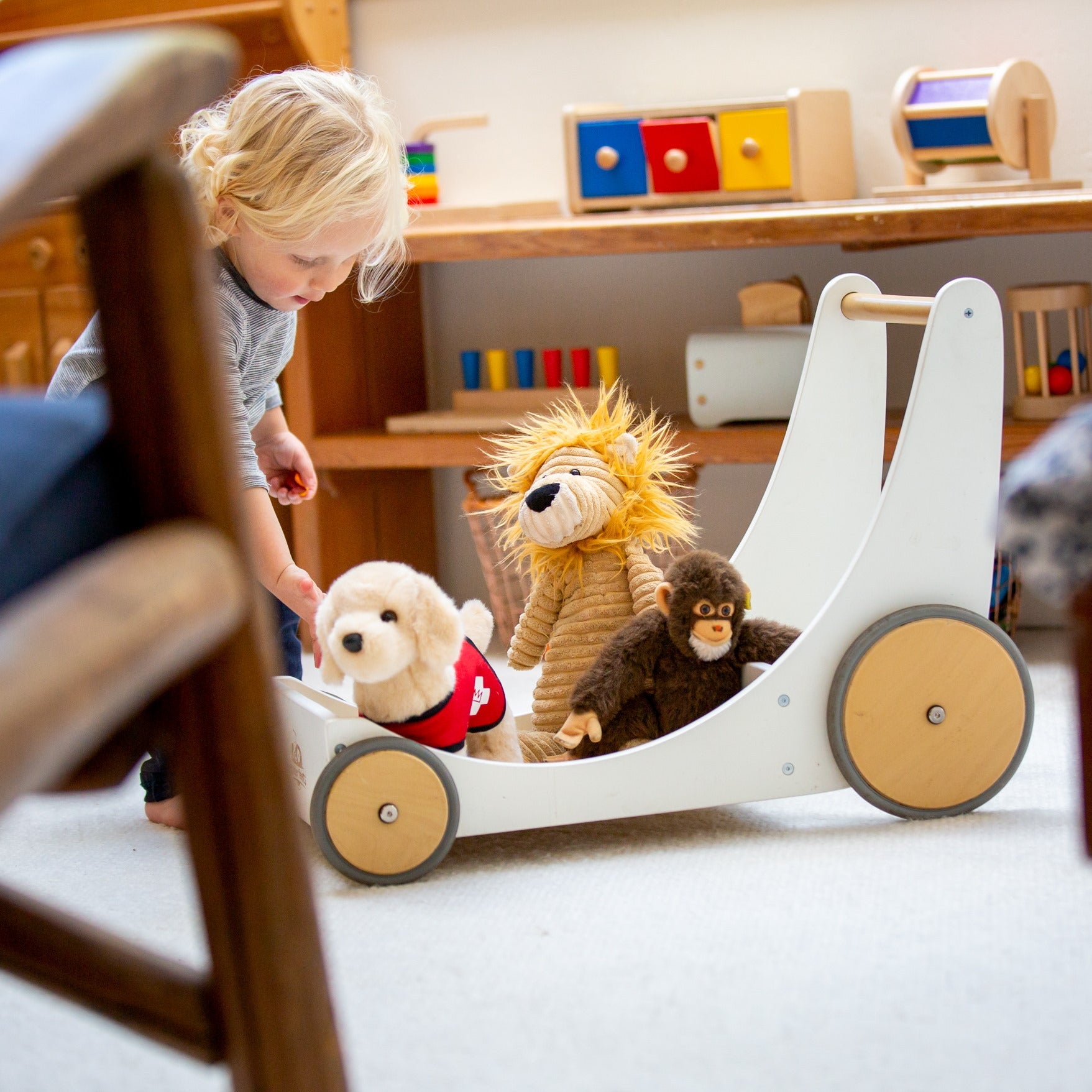 Wooden Kinderfeets Cargo Walker in white, a sturdy toddler push toy with cargo storage and colorful wheels for early walking fun.