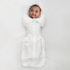 Love to Dream Swaddle Up™ Original 1.0 TOG swaddle in light fabric, featuring a baby sleeping peacefully inside the swaddle.