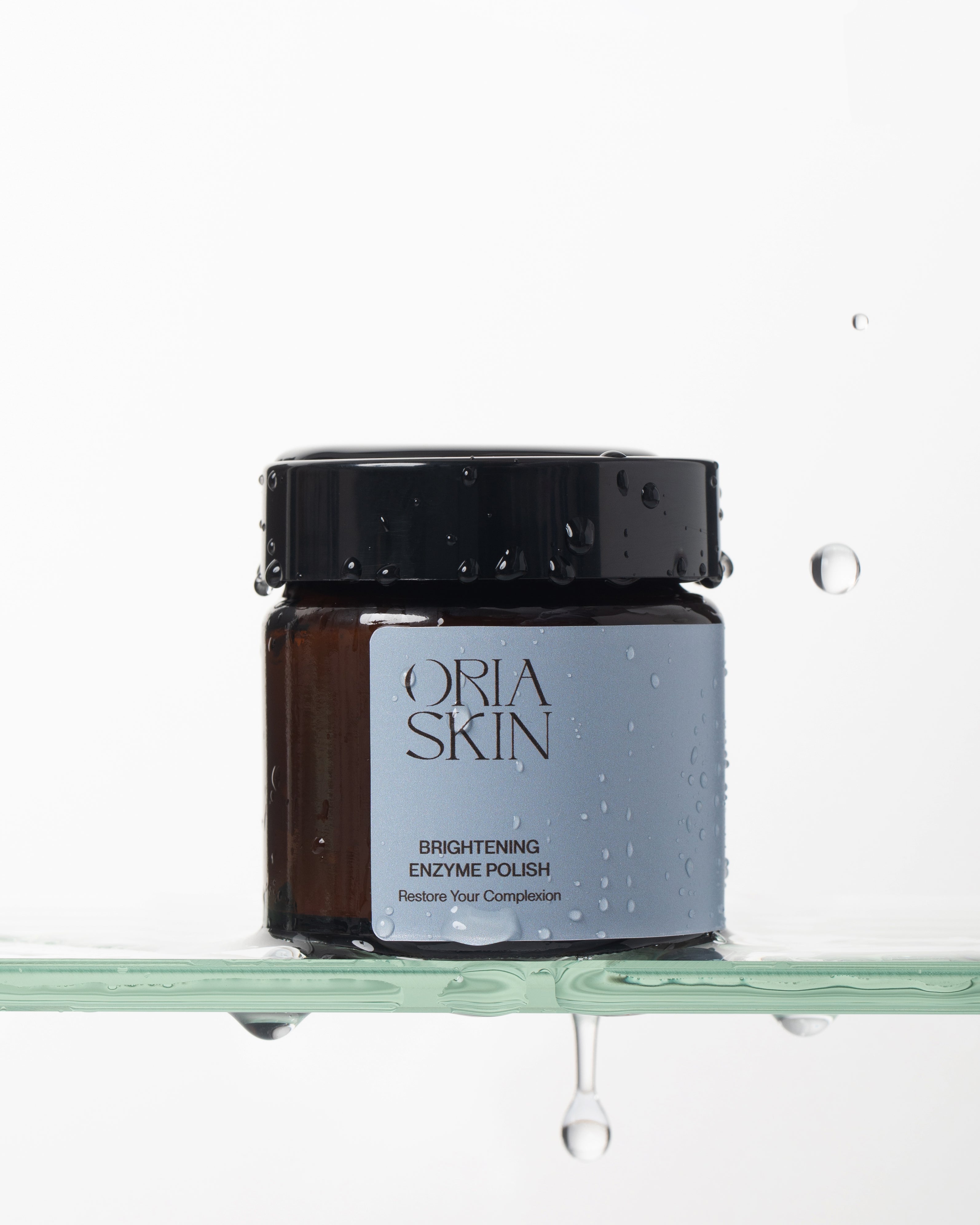 Oria Skin Brightening Enzyme Polish in a 65g jar with a smooth, creamy texture and vibrant packaging.