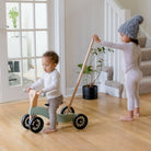 Kinderfeets Tiny Glider toy with wooden frame and colorful wheels, designed for young children to ride and play outdoors.