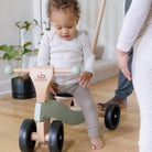 Kinderfeets Tiny Glider toy in vibrant colors, featuring a wooden frame and three wheels suitable for young children.