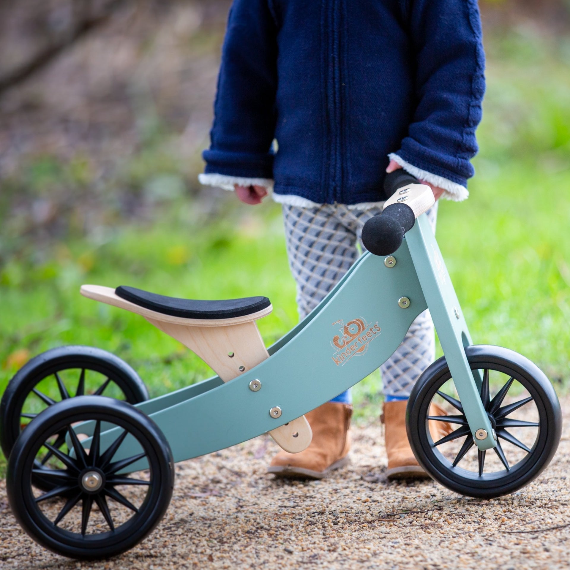 Kinderfeets Tiny Tot trike in sage green, a lightweight balance bike for young children, featuring a sturdy frame and playful design.
