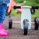 Kinderfeets Tiny Tot trike in sage green, a kids' balance bike with a sturdy frame and colorful design for young children.