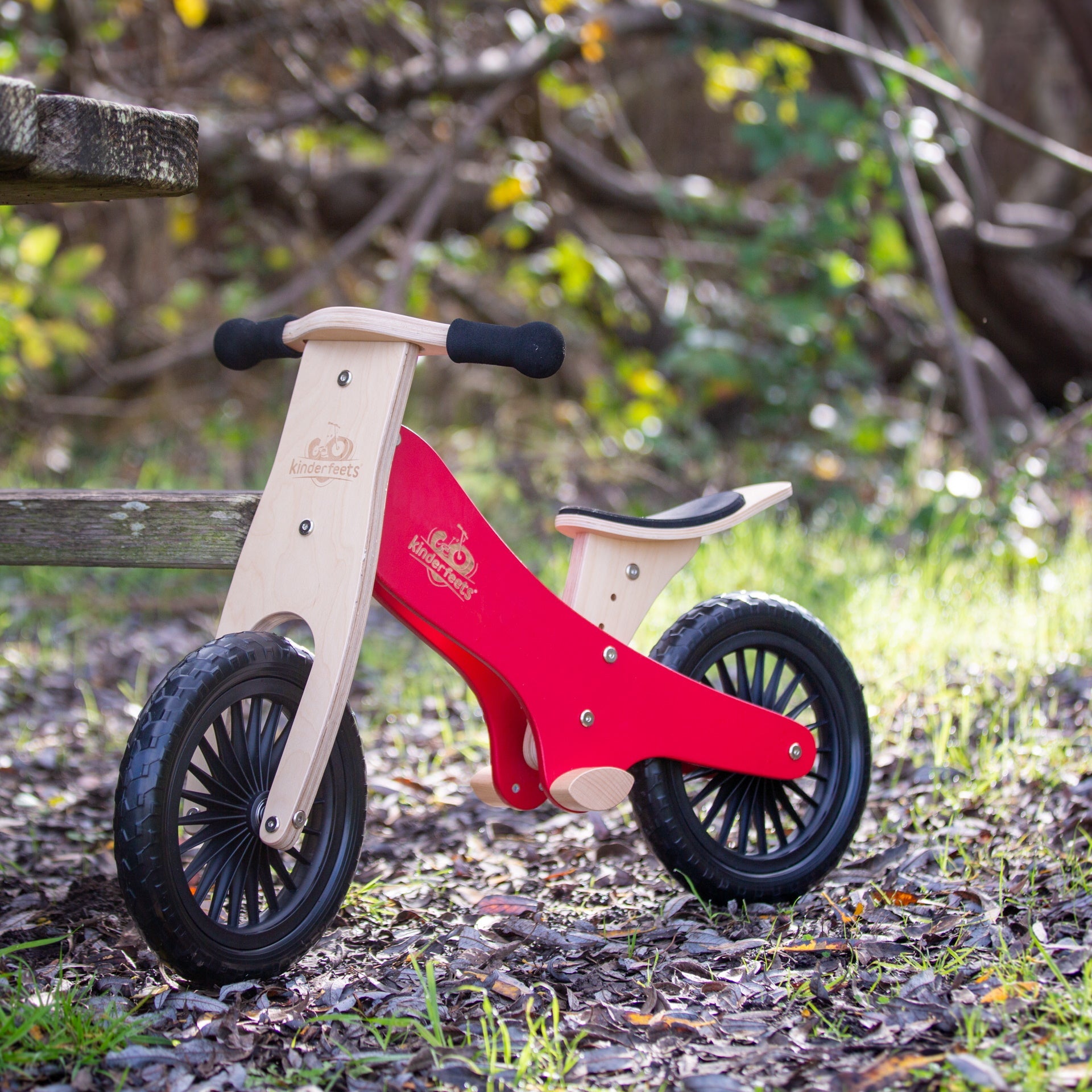 Kinderfeets Cherry Red balance bike for kids, featuring a sturdy wooden frame and colorful design, ideal for young beginners.