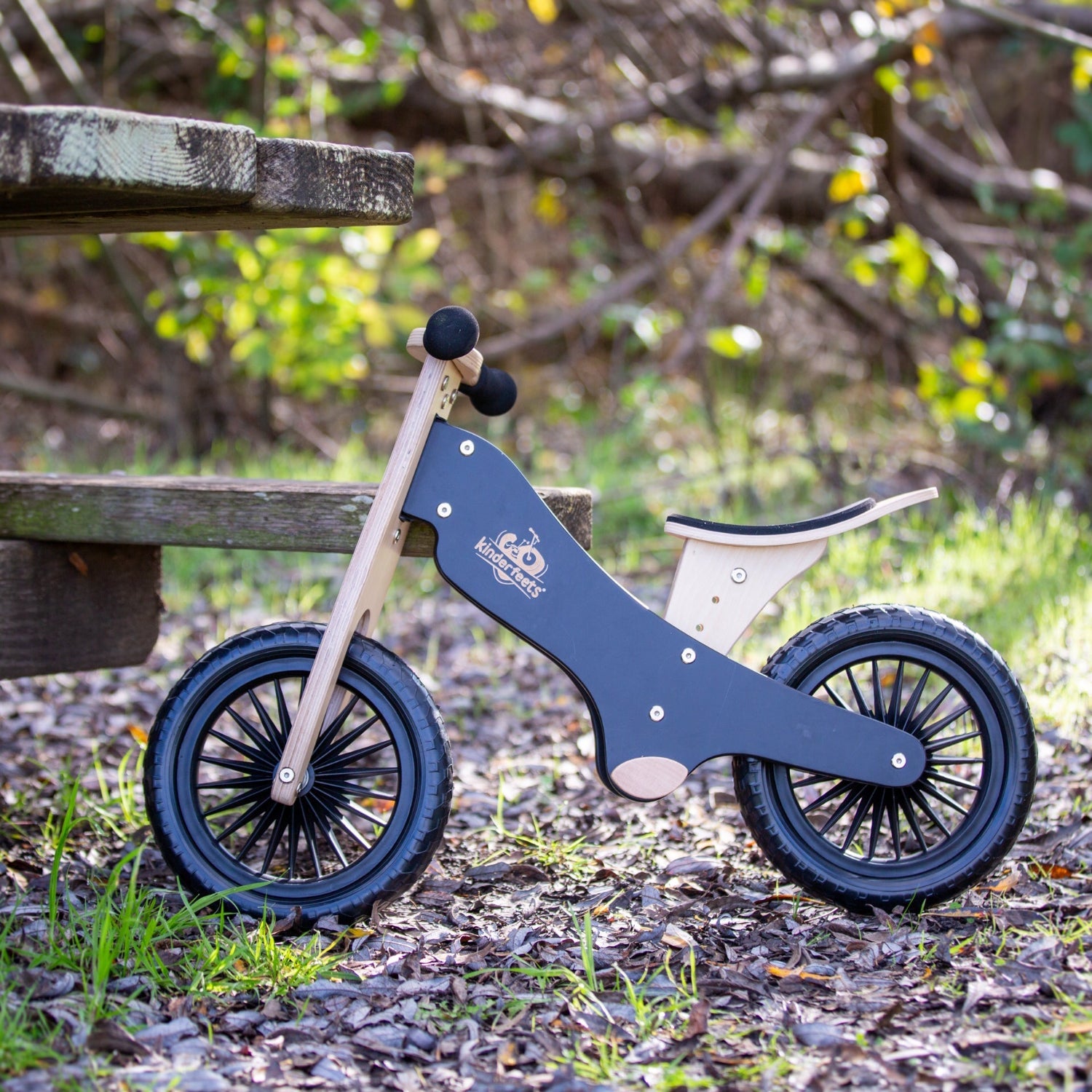 Kinderfeets black balance bike for kids with a sleek frame and training wheels, designed for young children learning to ride.