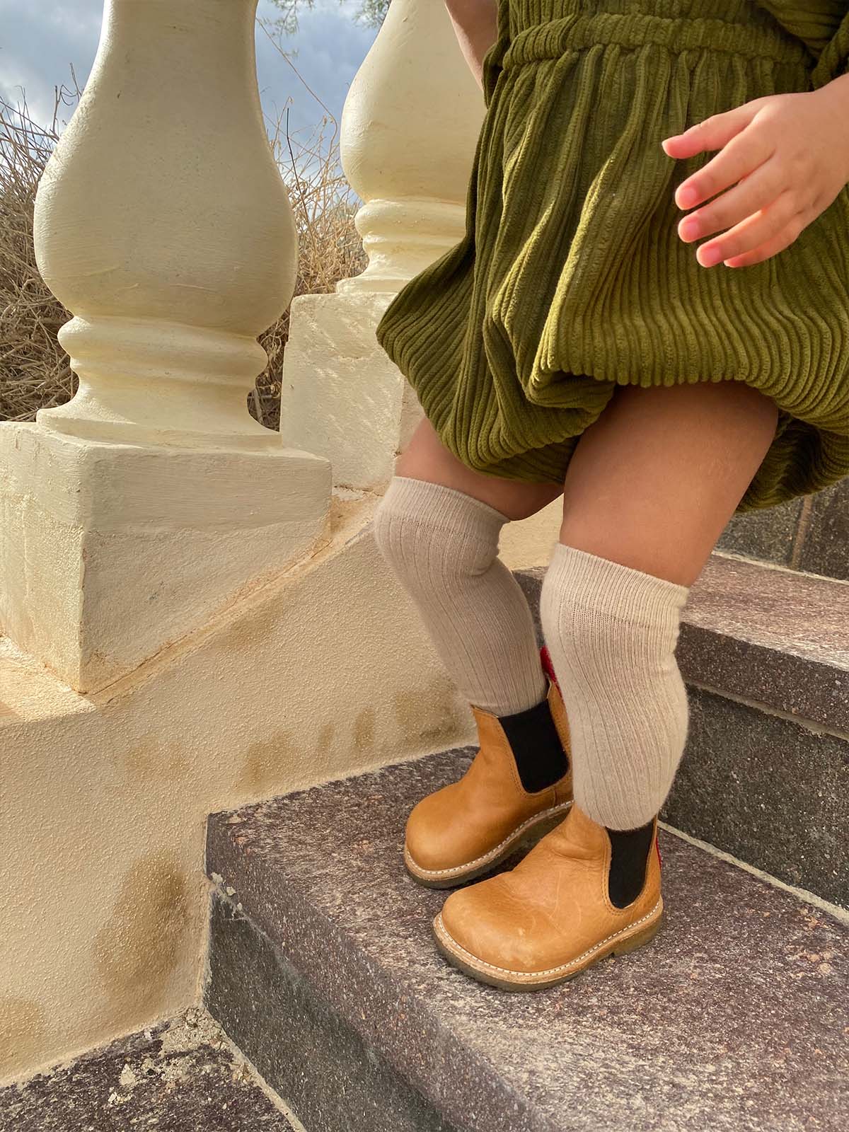 Organic cotton over-the-knee socks by Grech & Co in buff color, showing soft, stretchy fabric and knee-high length on a neutral background.