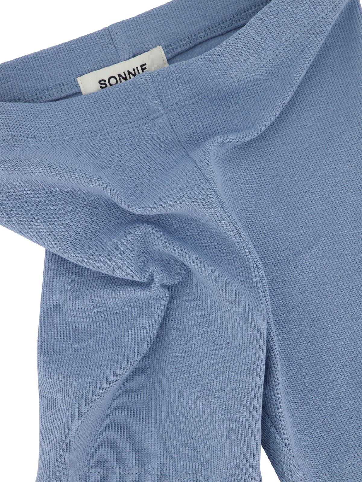 Sonnie Orla ribbed blue bike shorts shown with a close-up of the textured fabric and waistband detail.